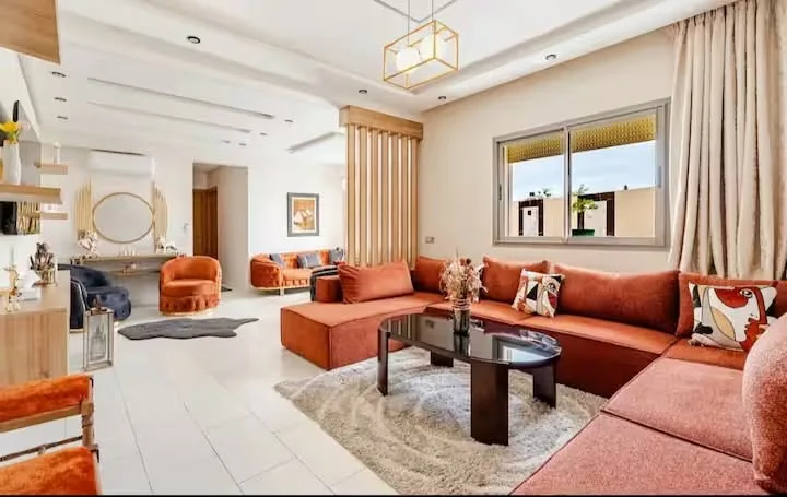 Salon lumineux orange et blanc, comparatif des meilleurs quartiers pour acheter un appartement à Agadir en 2026