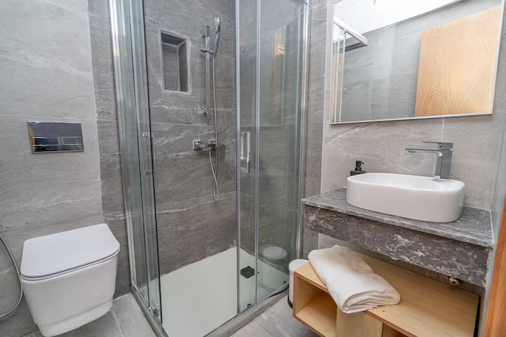 Salle d’eau ardoise à Agadir : douche italienne, WC suspendu et vasque — réalisation DARNÉO