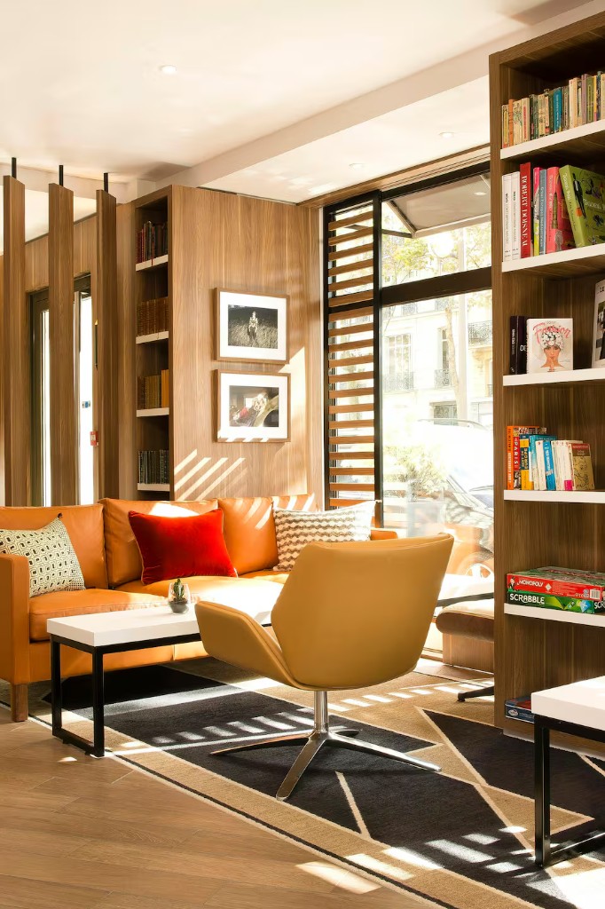Salon duplex avec mur bibliothèque et fauteuils tons chauds — Agadir Bay, DARNÉO